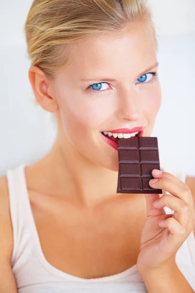 Jen malý kousek... Usmívající se mladá žena těší lahodný kus čokolády. — Stock fotografie