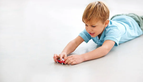 Vroom Vroom. Tiro de un niño adorable jugando con un coche de juguete. — Foto de Stock