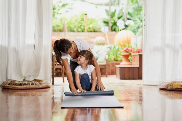 J'enseigne pas à pas à ma fille. Prise de vue d'une jeune mère et fille joyeux faisant une pose de yoga ensemble tout en étant assis sur le sol. — Photo