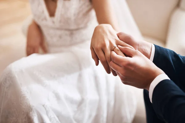 Навеки. Обрезанный снимок неузнаваемого жениха, надевающего бриллиантовое кольцо на палец своей жены во время их свадьбы. — стоковое фото