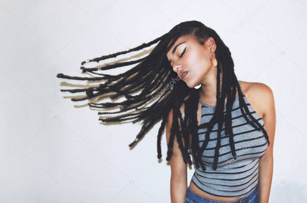 Not a care in the world. Studio shot of an attractive young woman throwing her hair.