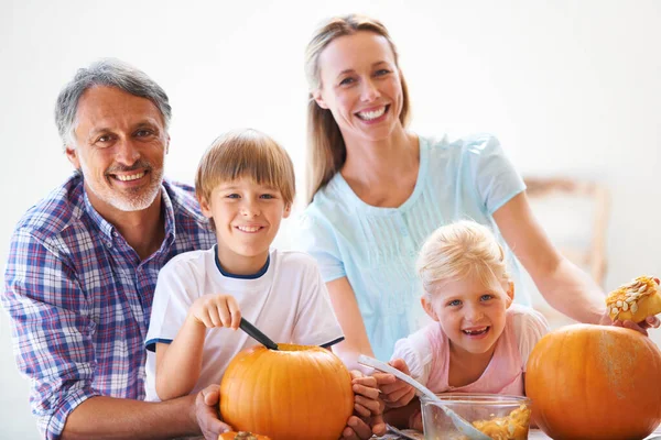 Familietradities. Portret van een familie van vier hollende pompoenen voor Halloween. — Stockfoto