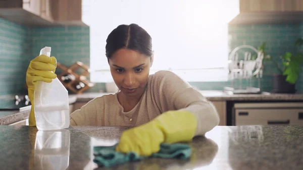 Gotta get every spot. Shot of a young woman scrubbing down her kitchen counter at home. — Stock Photo, Image