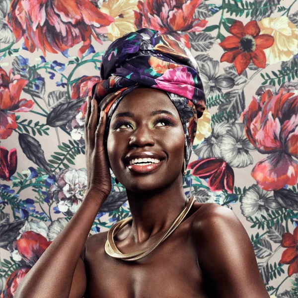 Emballez-vous comme le cadeau que vous êtes. Plan studio d'une belle jeune femme portant un foulard africain traditionnel sur fond floral. — Photo