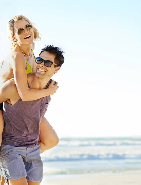 Stark genug für uns beide. Schuss eines Mannes, der seine Freundin am Strand trägt. — Stockfoto