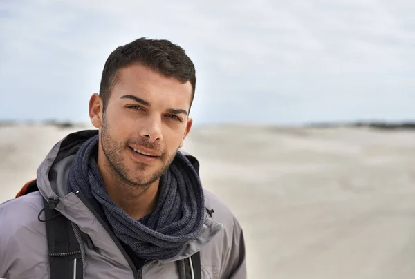 Inget klimat är för mycket. Porträtt av en ung manlig vandrare som vandrar längs sanddynerna. — Stockfoto