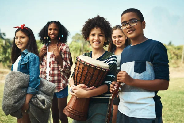 Um verão que não esquecerão em breve. Tiro de um grupo de adolescentes tocando instrumentos musicais na natureza no acampamento de verão. — Fotografia de Stock
