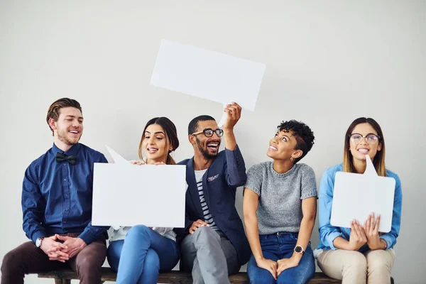 Laten we een boodschap in gedachten houden. Opname van een divers groepje creatieve medewerkers die spraakbelletjes binnen omhoog houden. — Stockfoto