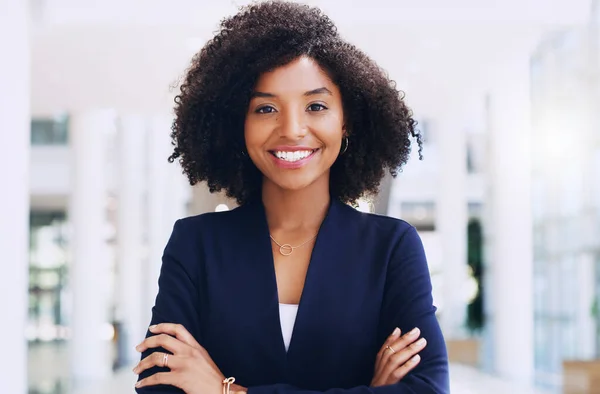 Orgulho-me de quão longe cheguei. Retrato recortado de uma atraente jovem empresária sorrindo e de pé no escritório com os braços cruzados durante o dia. — Fotografia de Stock