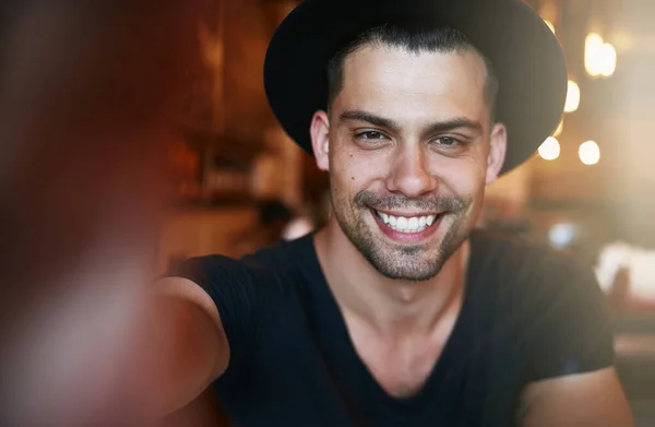 Sonríe si eres un cliente satisfecho. Retrato de un joven guapo tomando una selfie en una cafetería. —  Fotos de Stock