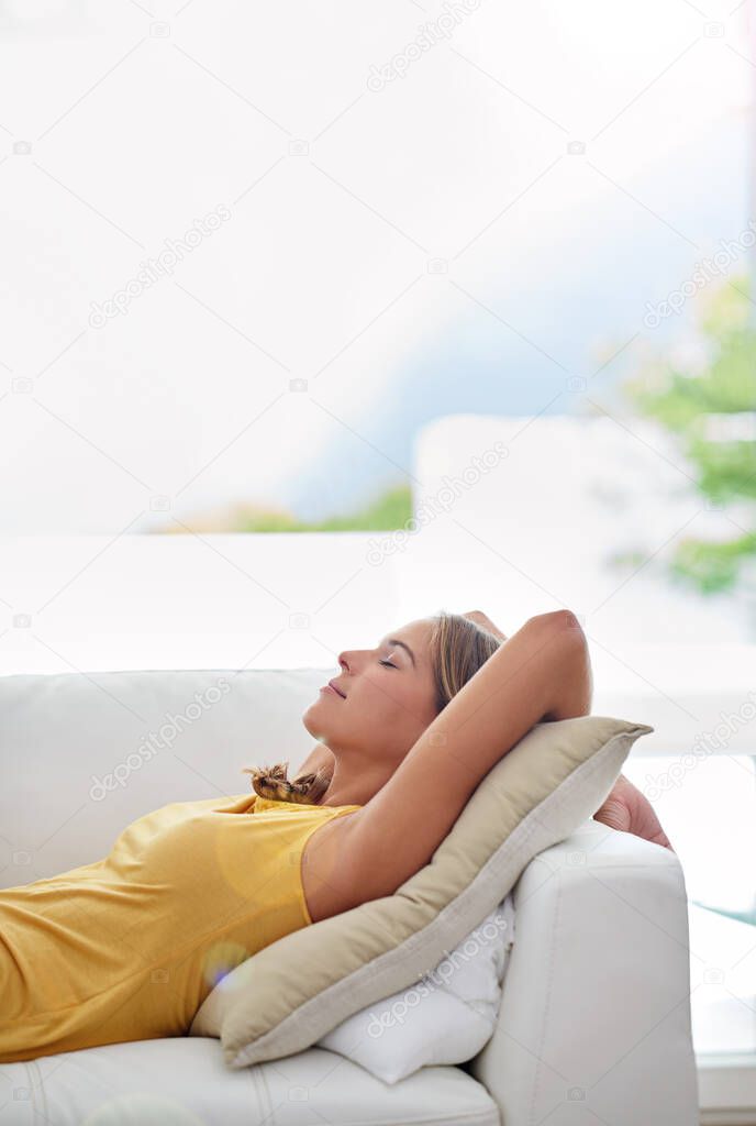 Naps are the best part of a lazy weekend. Shot of a young blonde woman relaxing on the sofa at home.