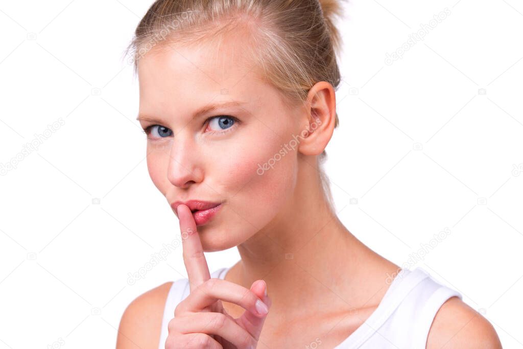 Keep it secret. Portrait of a beautiful young woman with her finger to her lips isolated on white.