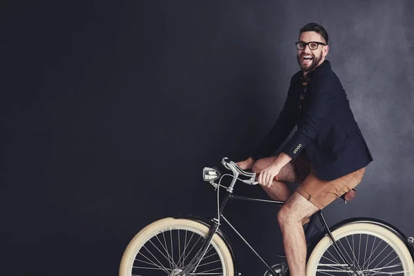 我想骑自行车就骑.一个时髦的年轻人在工作室骑自行车的画像. — 图库照片