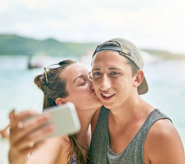 Selfie aimant. Tourné d'un couple heureux prenant un selfie sur la plage. — Photo
