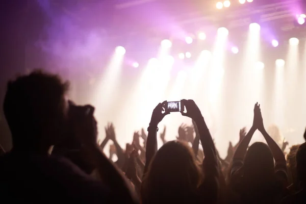 De band opblazen. Rearview shot van fans die een band filmen op het podium. — Stockfoto