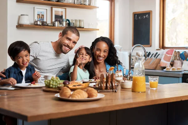 Le petit déjeuner vous mettra de bonne humeur. Tourné d'une famille de quatre personnes prenant le petit déjeuner ensemble à la maison. — Photo