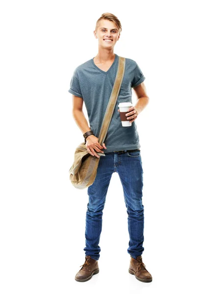 El java me mantiene en marcha. Un estudio de larga duración de un joven llevando una bolsa de mensajeros y sosteniendo una taza de café aislado en blanco. — Foto de Stock