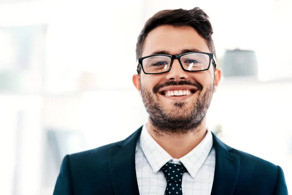 Я не могу не улыбаться, когда бизнес процветает. Обрезанный портрет красивого молодого бизнесмена, улыбающегося стоя в современном офисе. — стоковое фото