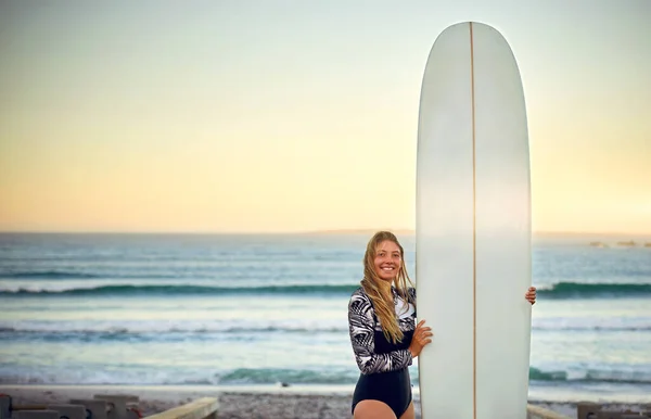 Potrzebuję tylko deski surfingowej. Portret atrakcyjnej surferki stojącej z deską surfingową na plaży. — Zdjęcie stockowe