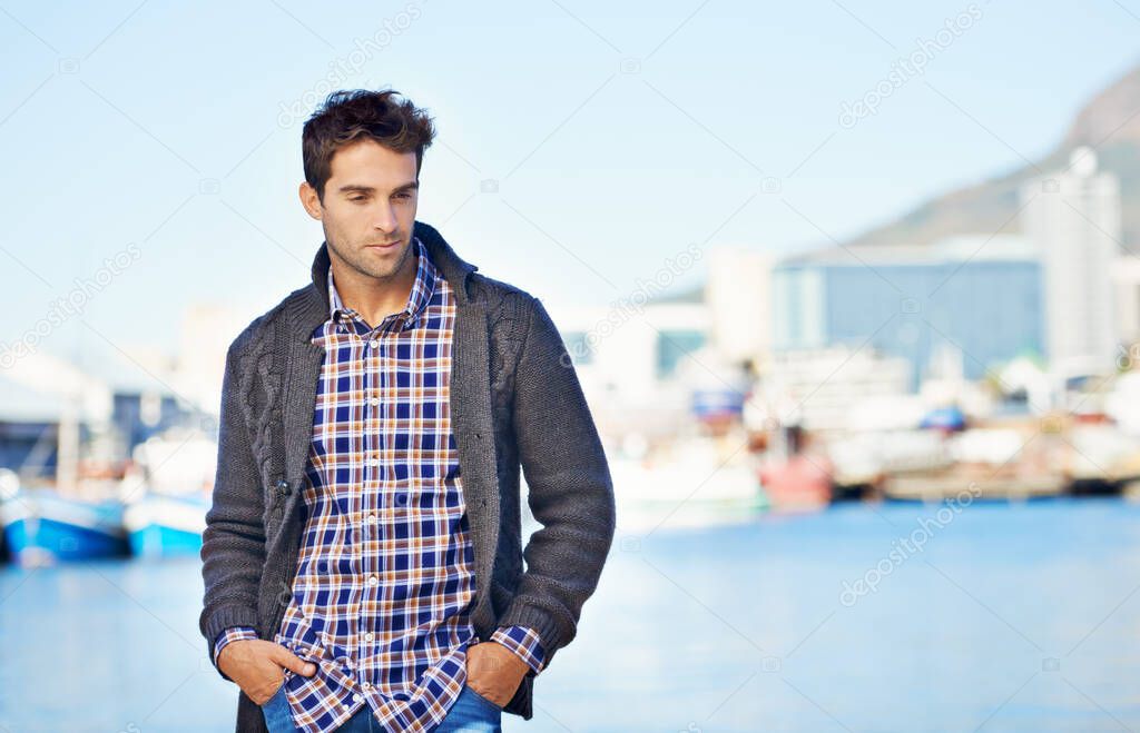 Spending a day at the waterfront. Shot of a handsome young man spending a day outdoors.