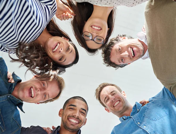 Part of a motivated team. Low angle shot of a team of people smiling down at the camera positively. — Stock Photo, Image