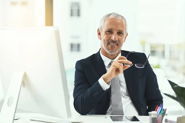 Llevar mi compañía a la cima. Retrato de un hombre de negocios maduro sonriente sentado en su escritorio en una oficina. —  Fotos de Stock