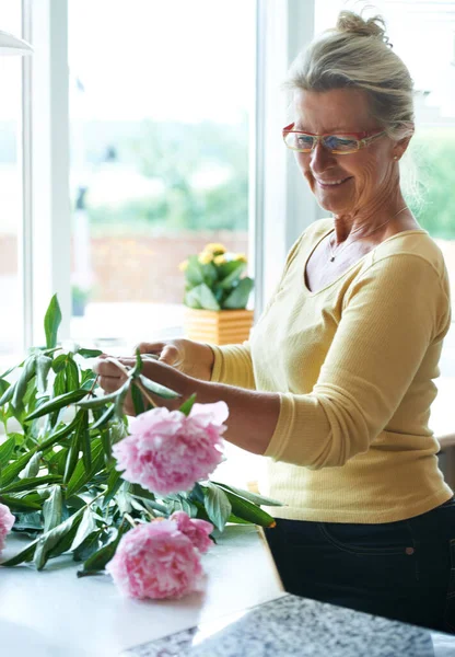 She loves flowers. A happy senior woman making a bouquet of flowers. — Stock Photo, Image