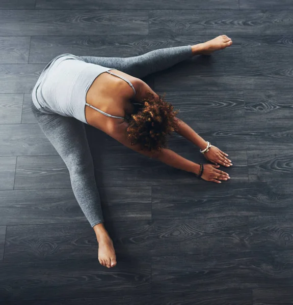Yogatiden er der. Høyvinklet bilde av en ung kvinne som øver på yoga. – stockfoto
