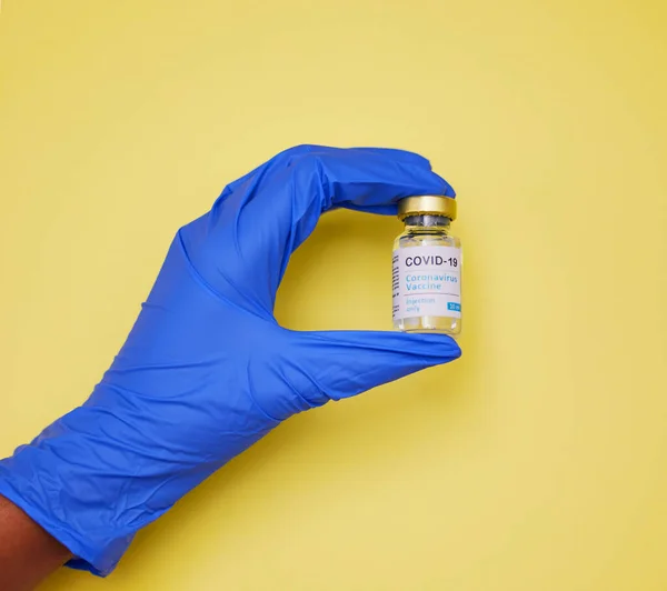 Jeder Impfstoff wird sorgfältig behandelt. Aufnahme einer unkenntlichen Person mit Impftuben vor gelbem Hintergrund. — Stockfoto