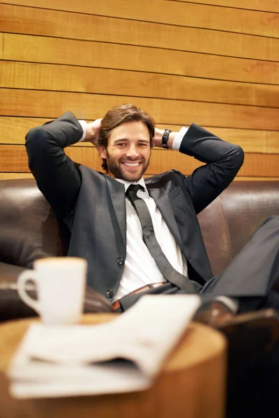 J'adore ma pause déjeuner. Un homme d'affaires heureux se relaxant sur un canapé dans un café. — Photo