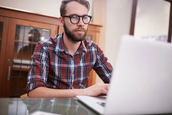 Wykorzystując najnowszą technologię. Zdjęcie przystojnego młodego hipstera pracującego na laptopie.. — Zdjęcie stockowe