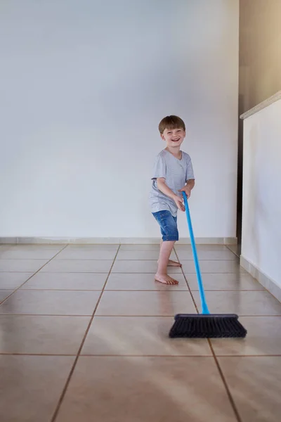 Sweeping is my chore for the day. Portrait of an adorable little boy using a broom to sweep the floor at home. — Stock Photo, Image