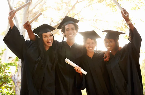 Positivo que vayan a lugares. Un grupo de graduados universitarios sonrientes celebrando su graduación. — Foto de Stock