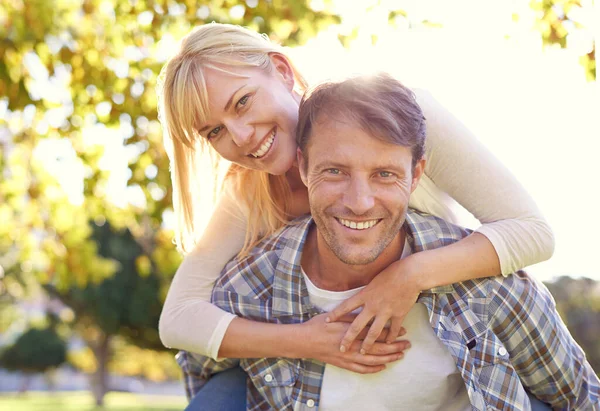 Sharing romantic moments. Shot of a happy man piggybacking his wife. — Stock Photo, Image