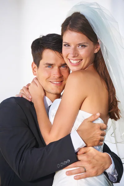 Vi kommer aldrig att släppa varandra. Porträtt av ett par unga nygifta omfamnar varmt och ler mot kameran. — Stockfoto