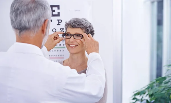 Este par é perfeito para ti. Tiro de um optometrista colocando um par de óculos em um paciente. — Fotografia de Stock