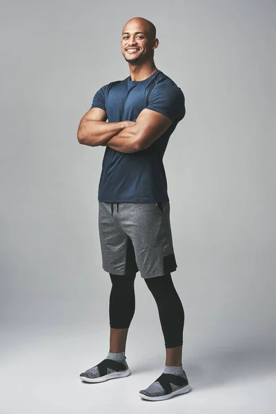 Je suis accro au fitness. Portrait studio d'un jeune homme athlétique debout les bras croisés sur un fond gris. — Photo