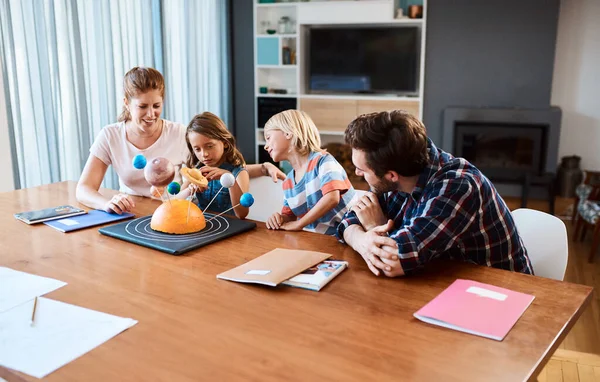 Ella va a apoderarse del mundo algún día. Foto de una hermosa familia joven trabajando juntos en un proyecto de ciencia en casa. —  Fotos de Stock