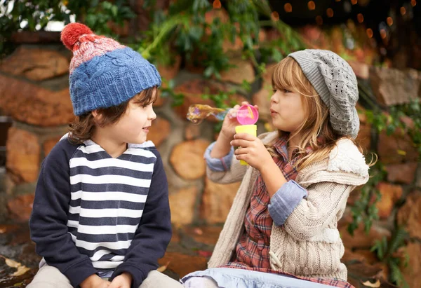 Ich bin mit den Blasen an der Reihe. Aufnahme von zwei niedlichen Kindern, die gemeinsam Blasen im Freien pusten. — Stockfoto