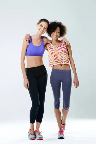 Mes copines de fitness. Deux belles jeunes femmes souriantes à la caméra en vêtements de sport. — Photo