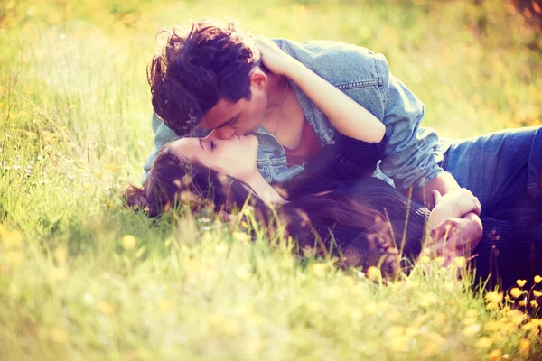Молодой роман. Винтажный образ молодой пары, целующейся романтически в летнем поле. — стоковое фото