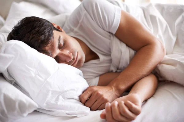 Sweet dreams. Shot of a young man sleeping in bed. Stock Picture