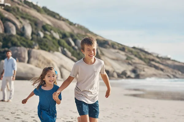 Έλα, τρέχα. Τραβηγμένο πλάνο ενός νεαρού αγοριού που κρατούσε το χέρι των αδελφών του και έτρεχε στην παραλία μαζί της.. — Φωτογραφία Αρχείου