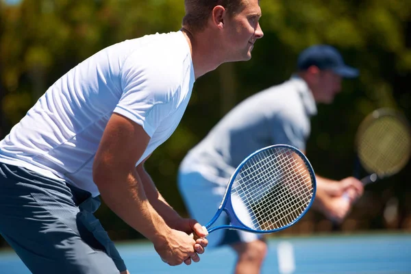 チームテニス。晴れた日にテニスの試合をする二人の男のショット. — ストック写真
