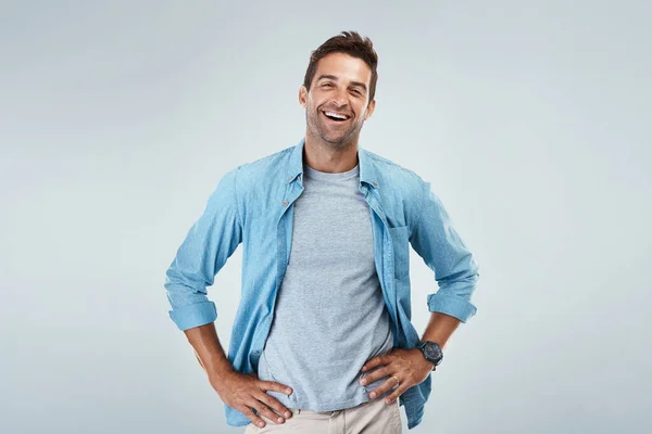 Redo att ta på sig dagen. Porträtt av en glad ung man som ler ljust när han står mot en grå bakgrund. — Stockfoto