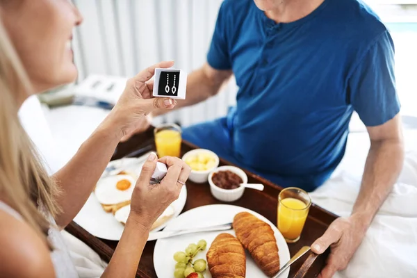 Les diamants sont un cadeau parfait pour votre anniversaire. Tourné d'un homme mature donnant sa femme avec une paire de boucles d'oreilles et petit déjeuner au lit à la maison. — Photo