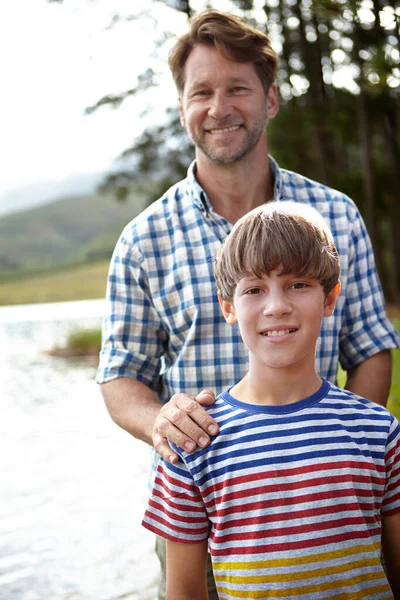 Oğlumla gurur duyuyorum. Gururlu bir baba ve oğlunun bir gölün yanında duran portresi.. — Stok fotoğraf