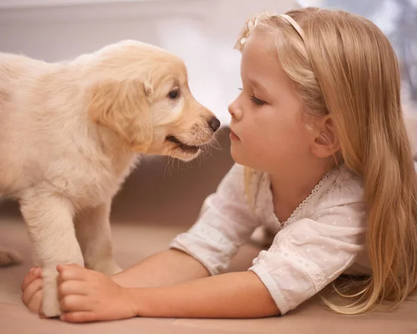 Le meilleur ami que tu puisses avoir. Une adorable petite fille avec son chiot à la maison. — Photo