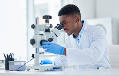 Ne ilginç bir buluş. Odaklanmış genç bir bilim adamının gün boyunca laboratuarın içinde mikroskopla test örneklerine baktığı görüntüler..