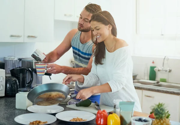 Ravviva la loro relazione. Girato di una giovane coppia felice che cucina insieme nella loro cucina a casa. — Foto Stock